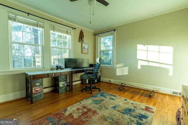 home office featuring crown molding, visible vents, ceiling fan, baseboards, and hardwood / wood-style flooring