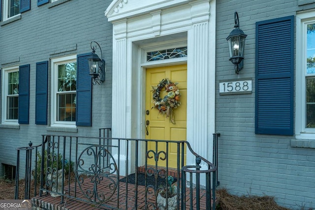 view of exterior entry featuring brick siding