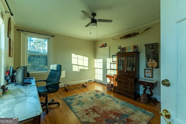 office with ceiling fan, baseboards, crown molding, and wood finished floors