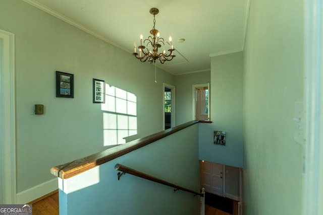 stairway with an inviting chandelier, baseboards, crown molding, and wood finished floors