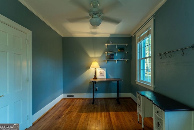 unfurnished office featuring ceiling fan, baseboards, crown molding, and wood finished floors