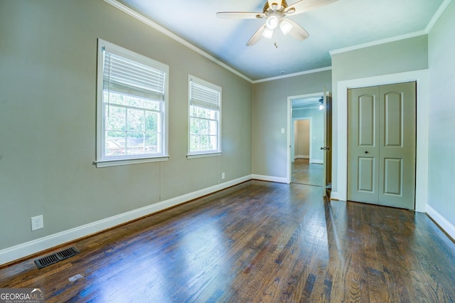 unfurnished bedroom with crown molding, visible vents, ceiling fan, wood finished floors, and baseboards