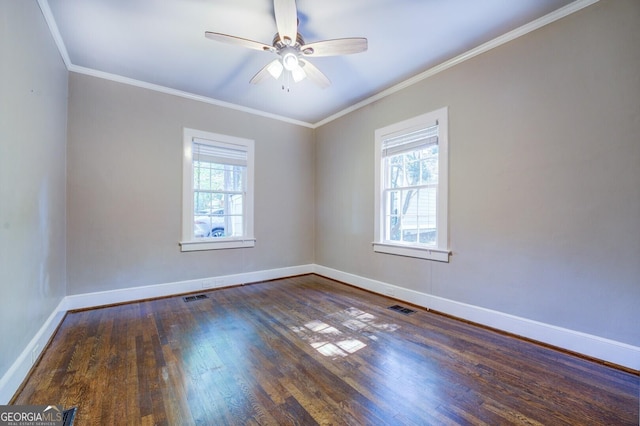 spare room featuring baseboards, visible vents, wood finished floors, and ornamental molding