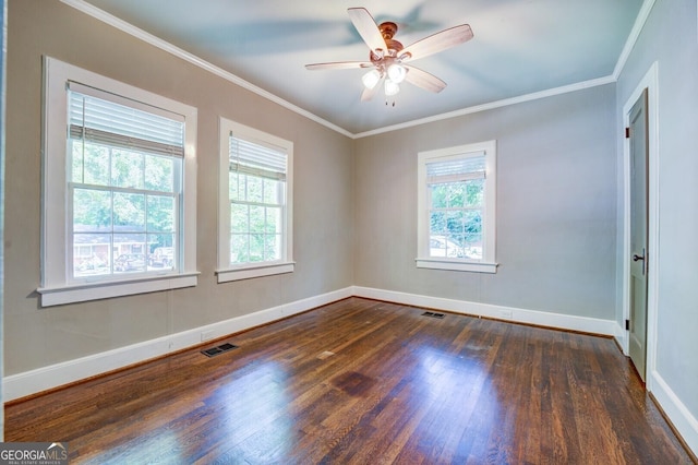 spare room featuring ornamental molding, dark wood finished floors, visible vents, and baseboards