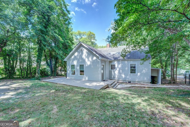 rear view of property with a shingled roof, a lawn, a chimney, fence, and a patio area