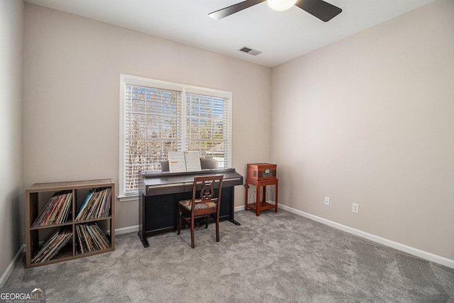 carpeted office with baseboards, visible vents, and a ceiling fan