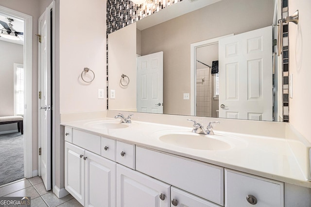 bathroom featuring double vanity, tile patterned flooring, walk in shower, and a sink