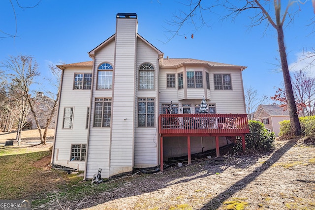 rear view of property featuring a deck and a chimney