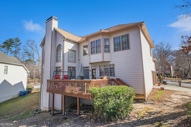 rear view of property featuring a wooden deck