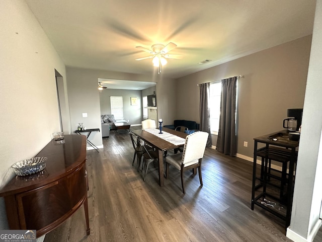 dining space with visible vents, dark wood-type flooring, a ceiling fan, and baseboards