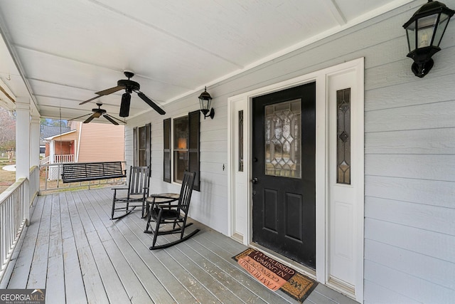 wooden terrace featuring a porch and a ceiling fan