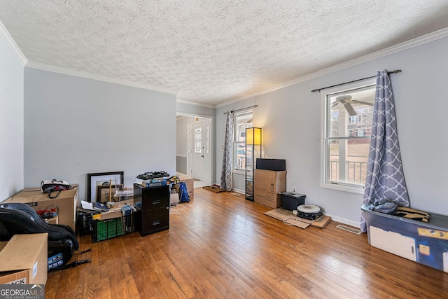 office area featuring a textured ceiling, wood-type flooring, baseboards, and crown molding