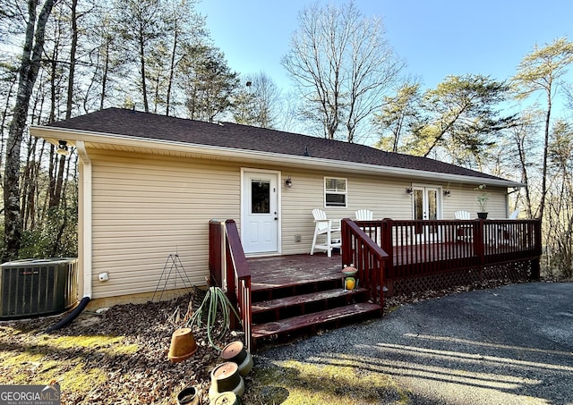 rear view of house with central AC, french doors, and a wooden deck