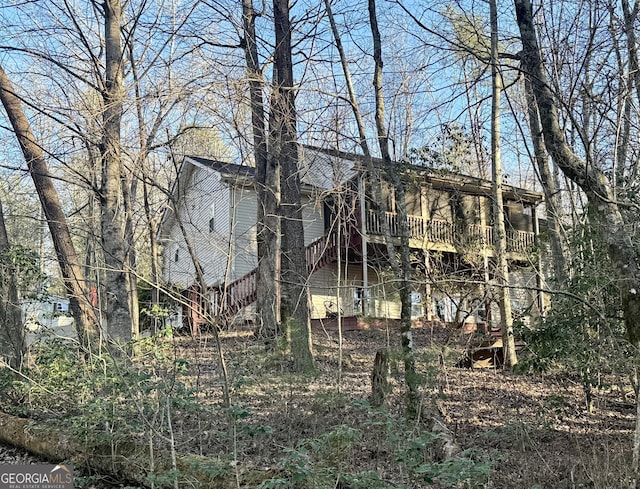 view of side of home featuring stairway and a wooden deck