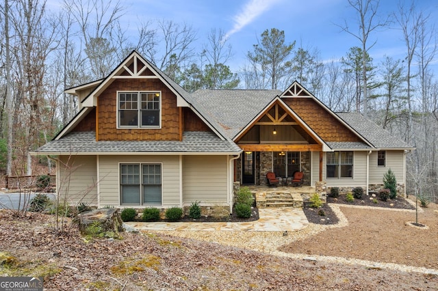 craftsman inspired home with a patio and roof with shingles