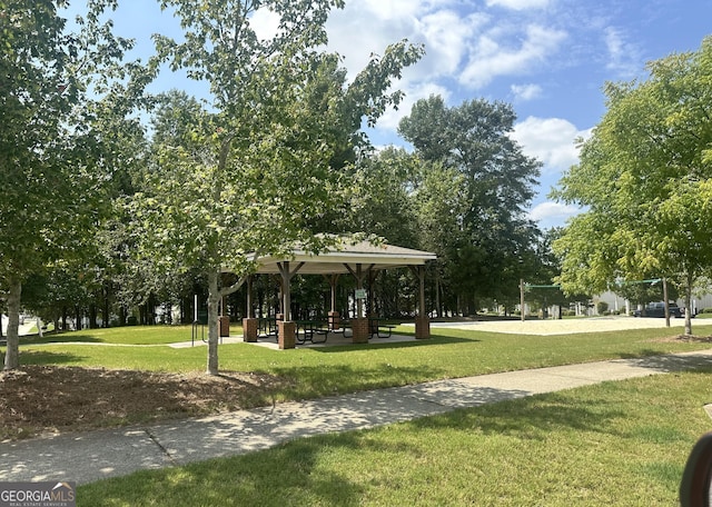 surrounding community with a gazebo, a lawn, and volleyball court