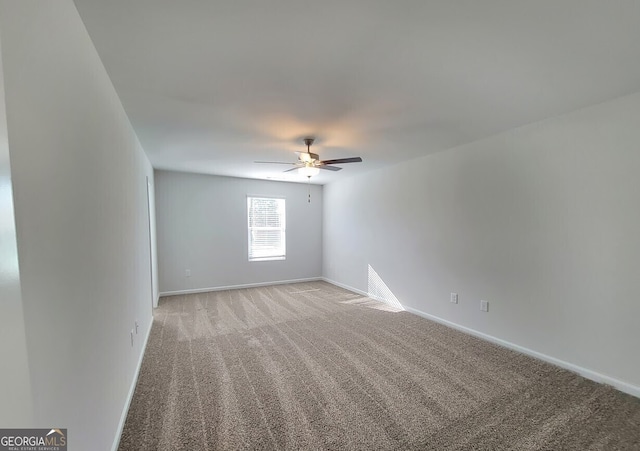 empty room featuring baseboards, a ceiling fan, and light colored carpet