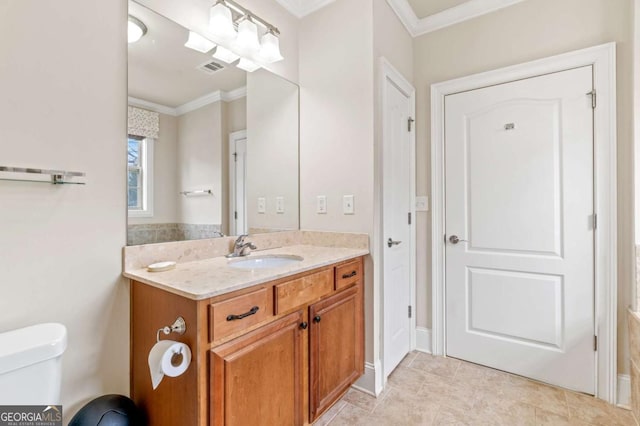 bathroom featuring toilet, visible vents, vanity, baseboards, and ornamental molding