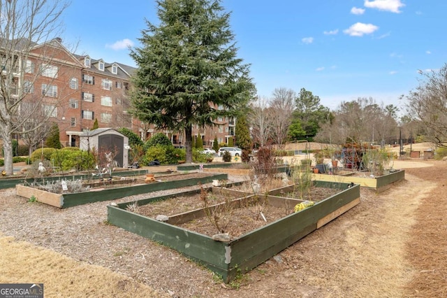 view of property's community with a garden, a storage unit, and an outdoor structure