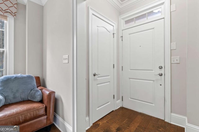 foyer entrance with dark wood-style floors, baseboards, and crown molding