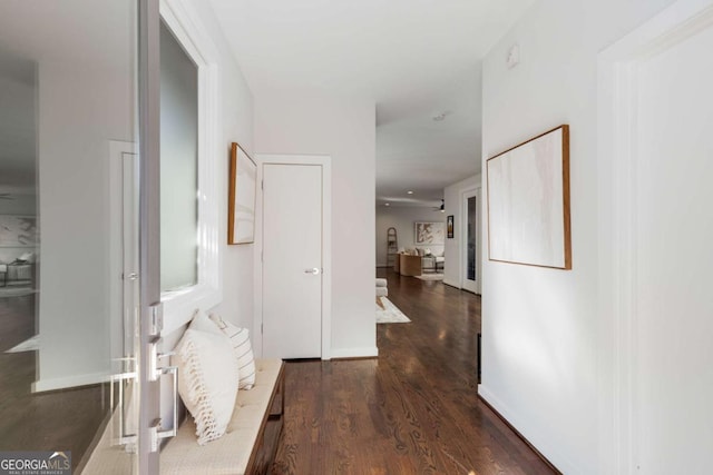 hall with baseboards and wood finished floors