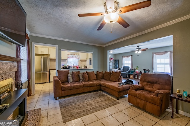 living room featuring ornamental molding, light tile patterned flooring, ceiling fan, and a textured ceiling