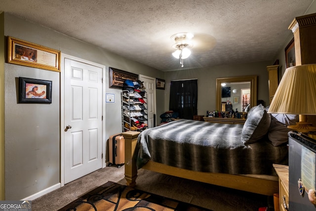 bedroom with a textured ceiling, carpet flooring, and baseboards