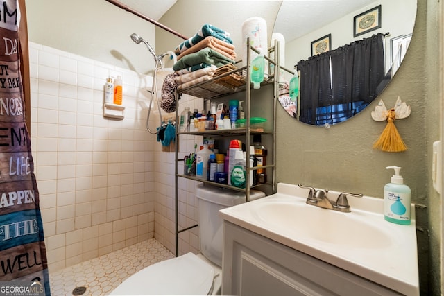 full bathroom with a textured ceiling, a textured wall, toilet, vanity, and a shower stall