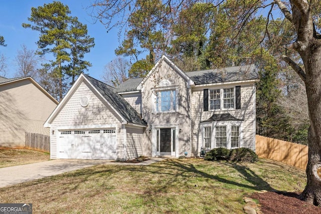 view of front facade with a front lawn, fence, driveway, and an attached garage