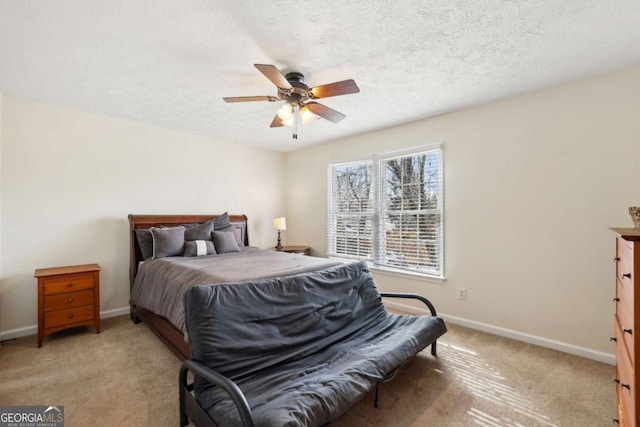 bedroom featuring a textured ceiling, ceiling fan, light colored carpet, and baseboards