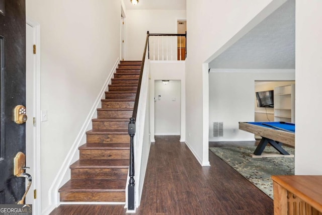 entrance foyer with billiards, visible vents, stairway, ornamental molding, and wood finished floors