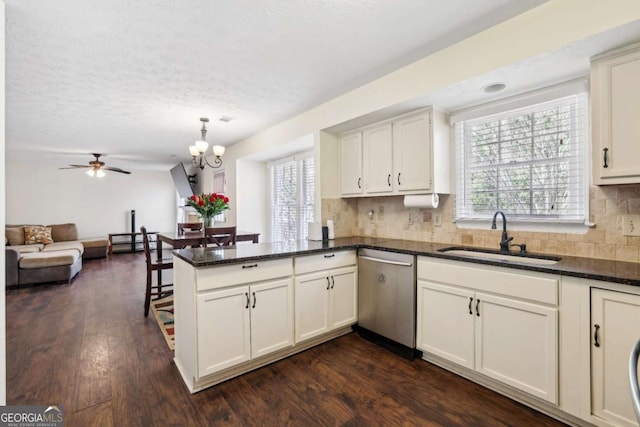 kitchen featuring white cabinets, dishwasher, dark wood-type flooring, a peninsula, and a sink