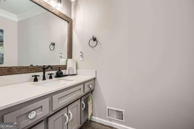 bathroom featuring visible vents, crown molding, vanity, and baseboards