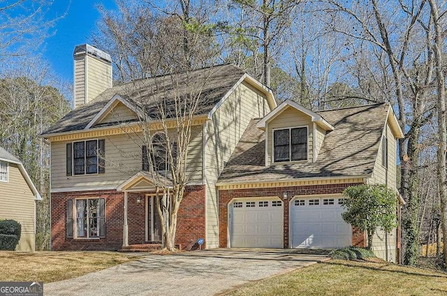 view of front facade with driveway, an attached garage, a chimney, and brick siding