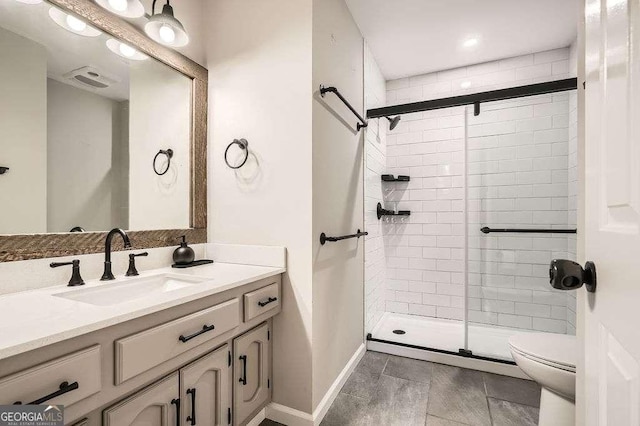 bathroom featuring toilet, a shower stall, baseboards, and vanity