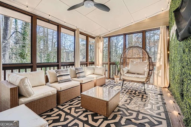 sunroom with a ceiling fan, a wealth of natural light, and lofted ceiling