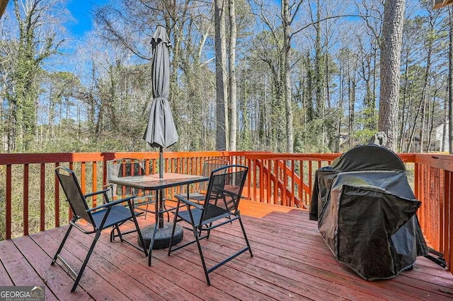 wooden deck with a grill and outdoor dining area