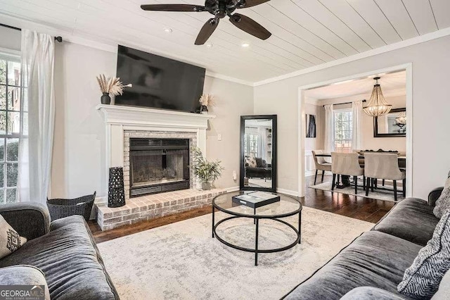 living room featuring wooden ceiling, a fireplace, wood finished floors, baseboards, and crown molding