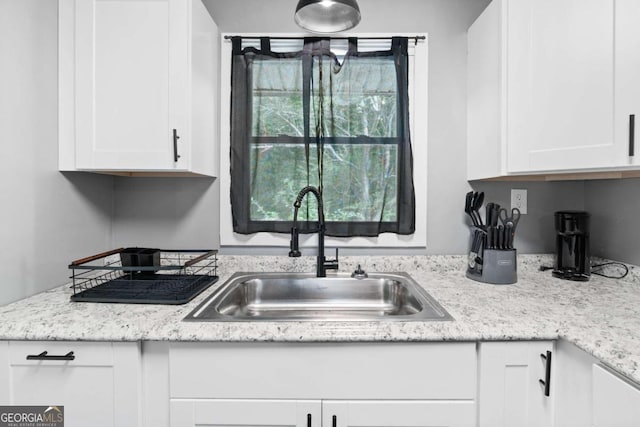 kitchen featuring white cabinets and a sink