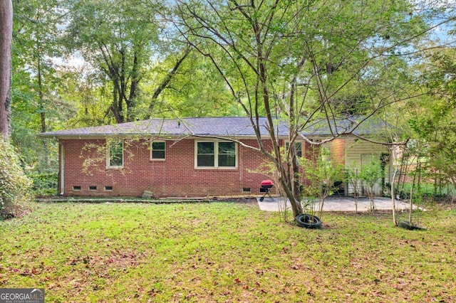 view of home's exterior with crawl space, a patio area, a yard, and brick siding