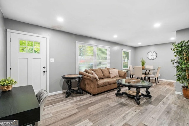 living room featuring light wood finished floors, baseboards, and recessed lighting