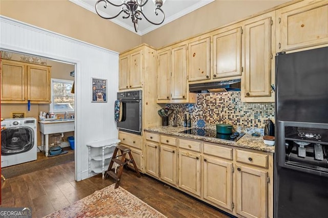 kitchen with under cabinet range hood, ornamental molding, decorative backsplash, black appliances, and washer / clothes dryer