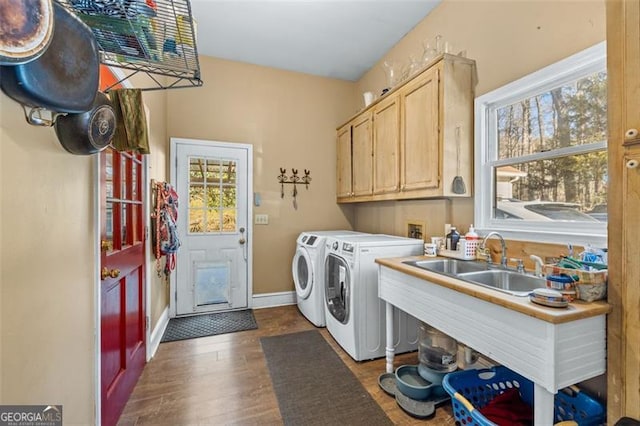 laundry room with washing machine and clothes dryer, cabinet space, dark wood-type flooring, a sink, and baseboards