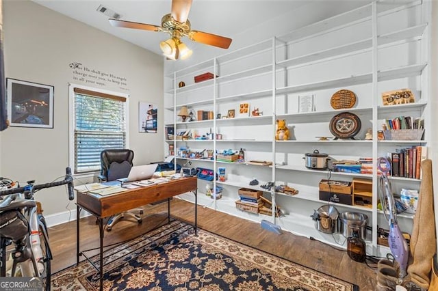 office space with baseboards, wood finished floors, visible vents, and a ceiling fan