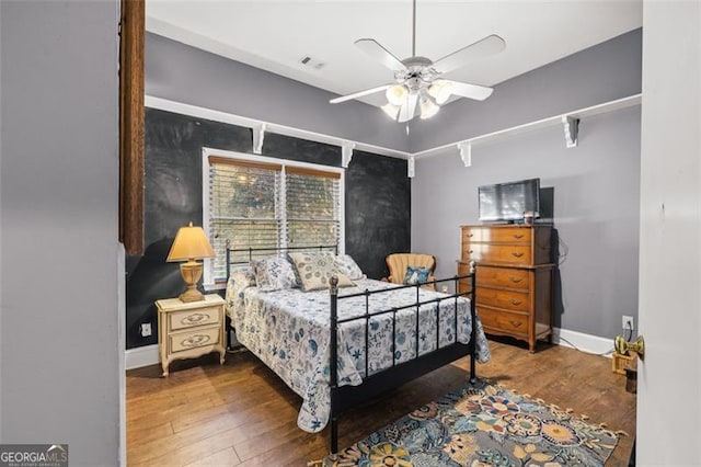 bedroom with a ceiling fan, baseboards, and wood finished floors