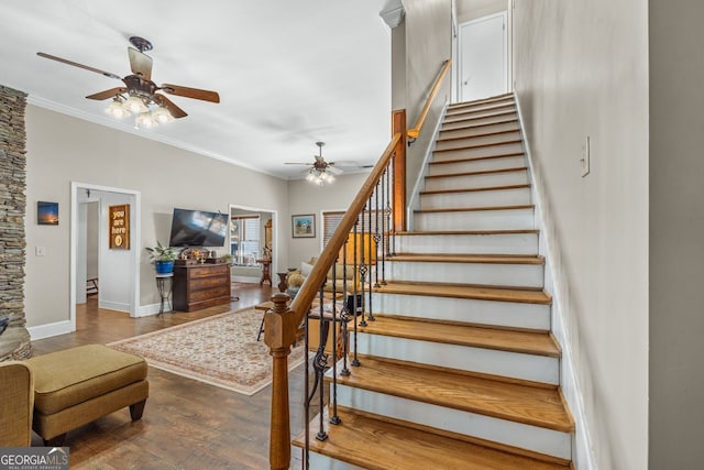 stairway with a ceiling fan, baseboards, crown molding, and wood finished floors