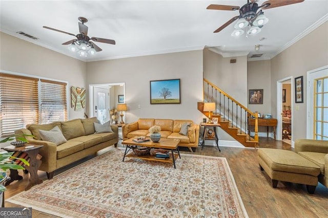 living room featuring visible vents, crown molding, stairway, and wood finished floors