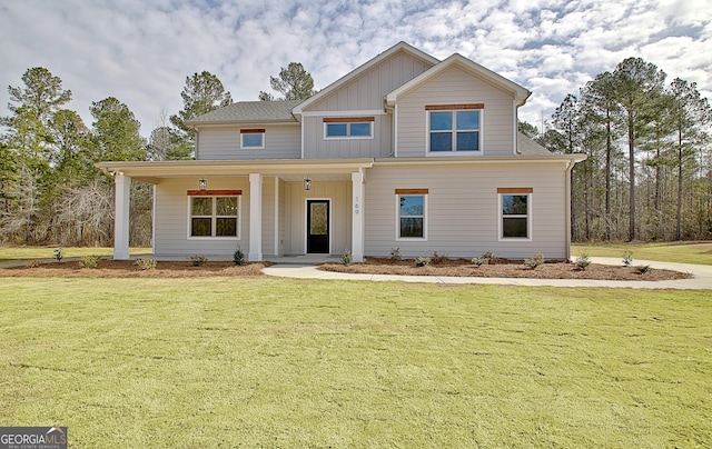 view of front facade with board and batten siding and a front yard