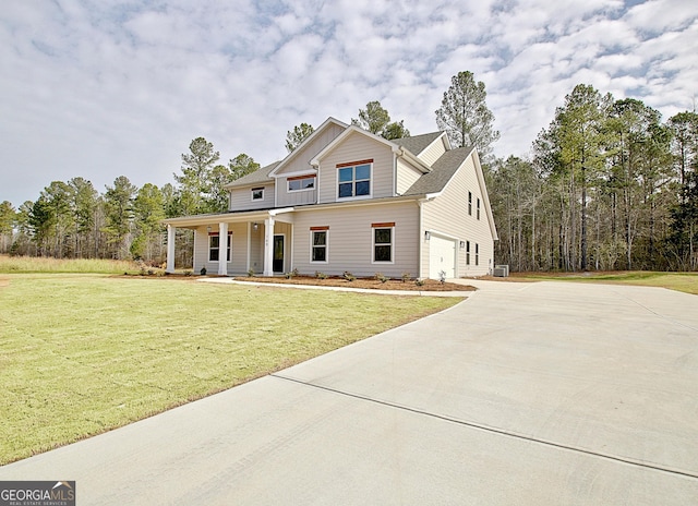 view of front of house with an attached garage, covered porch, driveway, and a front lawn