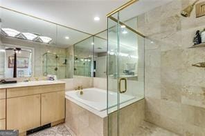 full bath featuring a stall shower, a garden tub, and vanity